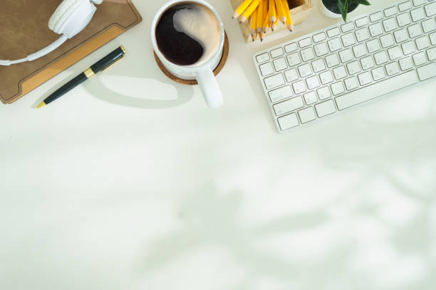 istock Top view white office desk with keyboard, coffee cup, headphone and stationery. 2168149700