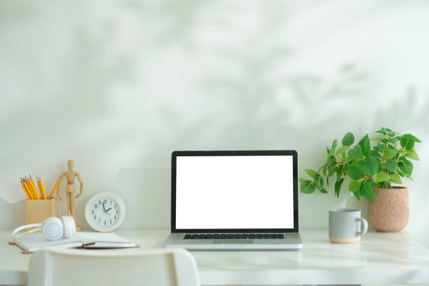 istock Mockup computer laptop, coffee cup, books and pencil holder on white table. 2168149760
