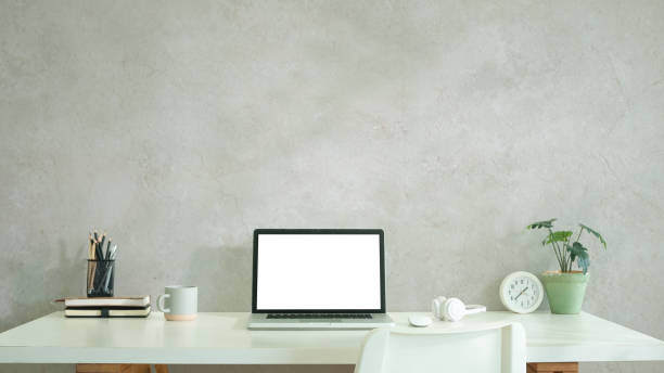 istock Laptop with white blank display, books, stationery and potted aplenty on white table. 2168150062