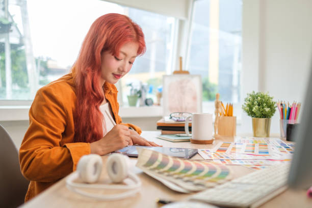istock Stylish young woman using graphics tablet and a stylus pen, working new project in home office. 2168150205