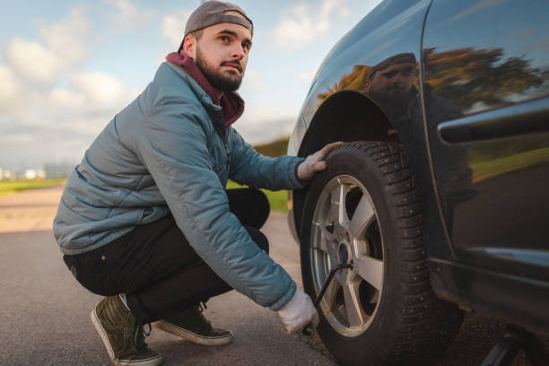 istock Young man changing tires on his car in preparation for winter 2168155411