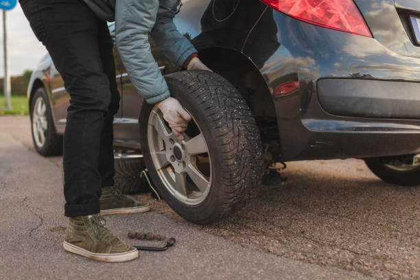 istock Young man inspecting the tires on his car before changing them 2168155454