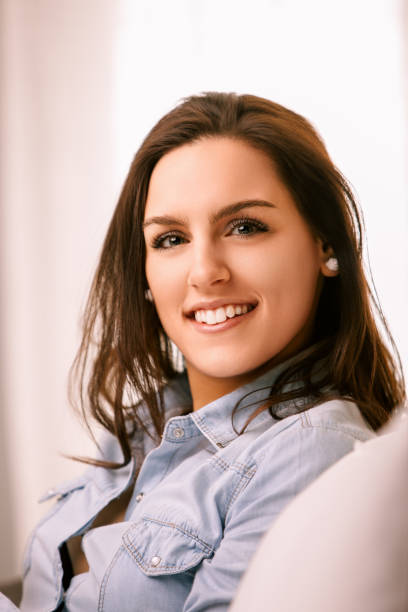 istock Young woman smiling and relaxing at home on the sofa 2168157300
