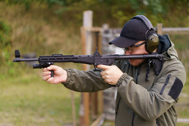 istock A man is holding a gun and wearing a green jacket 2168159712