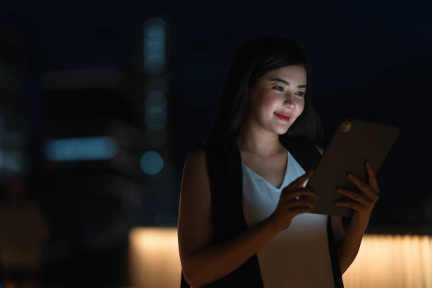 istock Woman Browsing on Tablet in the City at Night 2168160544