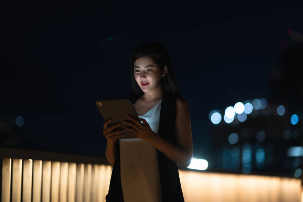 istock Woman Using Tablet on City Balcony at Night 2168160545
