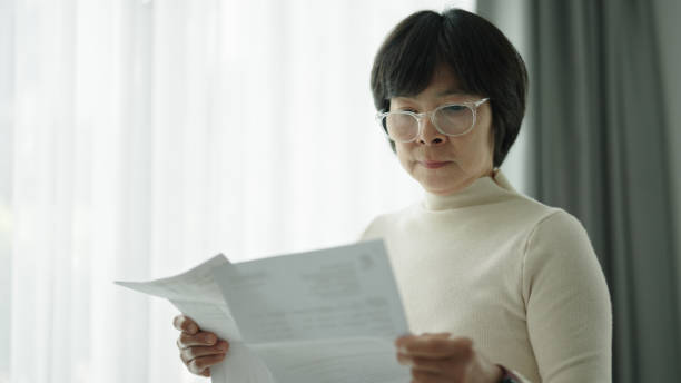 istock Mature woman looking at bill. 2168161547