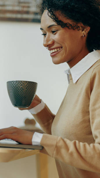 istock A woman is happily enjoying her coffee while focused on her tasks at a modern desk setup 2168164480