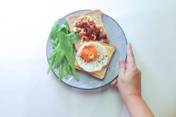 istock bread with egg and cheese topping or  sunny side up egg , lettuce and almond with dried cranberry and milk 2168168834