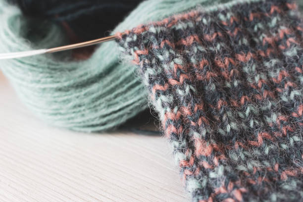 istock Colourful yarn ball with knitted sock and knitting needles. Alpaca and wool threads with beautiful knitting pattern. Woven crochet close up. Knitting hobby. Knitwear concept. 2168170747