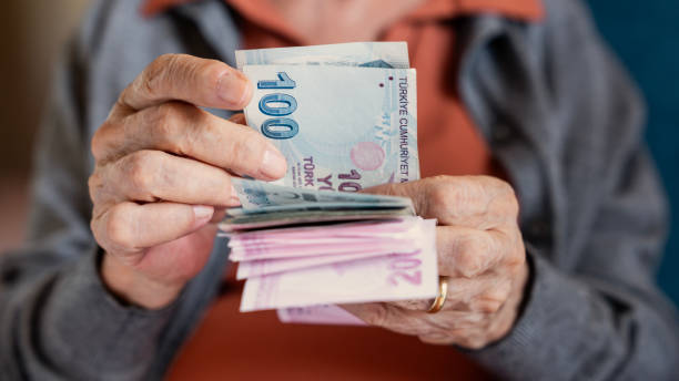 Old woman counting Turkish lira banknotes
