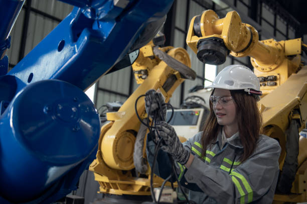 istock Engineer standing by robotic arm and operating machine in industry factory, technician worker check for repair maintenance electronic operation 2168175759