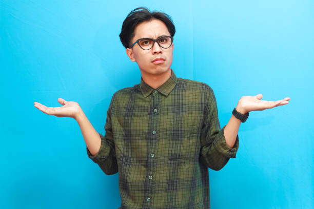 istock Handsome Asian man showing surprised or confused expression while looking forward on isolated blue background 2168178359