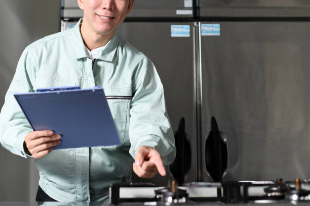 A male worker inspecting the stove in the kitchen