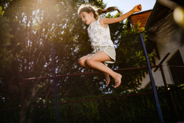 Silhouette Woman Jumping On Trampoline Against Sky During Sunset