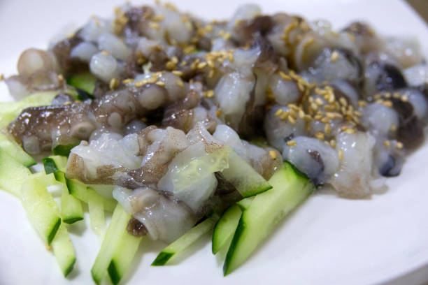 Stir-fried conch with celery on a plate on the marble dining table in the restaurant.
