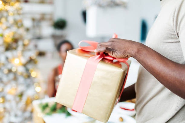 istock Friends exchanging Christmas presents at dinner table 2168203238