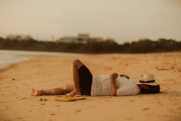 legs of an older woman sunbathing on the beach on a sun lounger, summer vacation concept