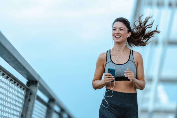 istock Female jogger running over the bridge 2168213367