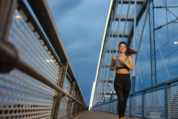 istock Energetic beautiful woman sprints across a modern bridge 2168214163