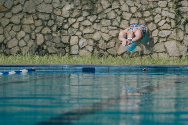 Asian Chinese female swimmer dive into water.