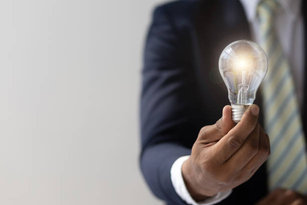istock Businessman hand holding light bulb and idea. 2168220999