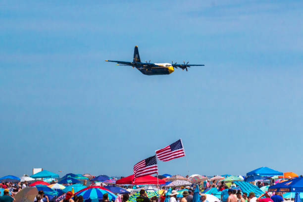 Wantagh, New York, USA - 29 May 2022: Blue Angels Fat Albert cargo ship flying over the crowd during an airshow on the beach on Long Island New York with a blue sky.
