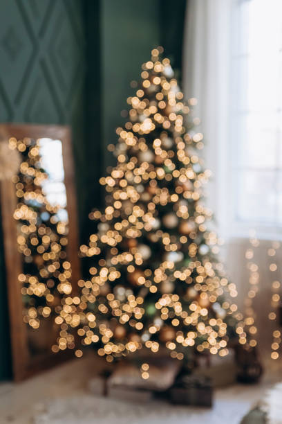 istock Festive background featuring a blurred Christmas tree adorned with bokeh lights. The soft focus adds a touch of holiday magic and warmth 2168223433