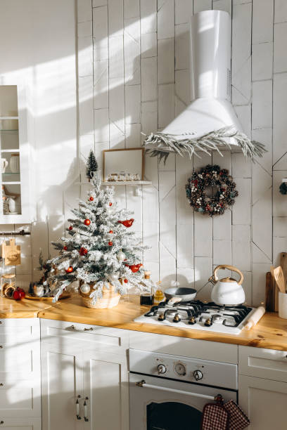 istock Sunlit kitchen featuring a frosted Christmas tree with red and white decorations, a festive wreath, and various kitchen items on the countertop, creating a warm holiday atmosphere 2168224614