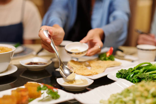 istock Woman Putting Sauce In Bowl At Dinner 2168225657