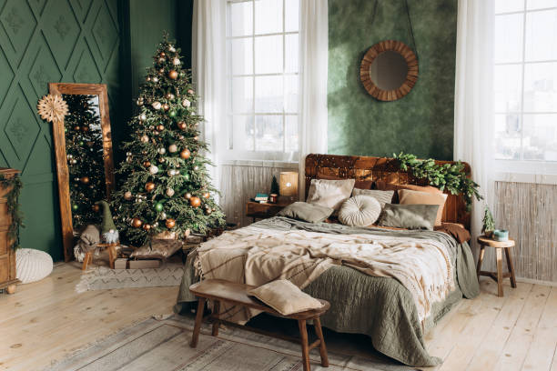istock Airy bedroom filled with sunlight, Christmas tree, cozy bed, large windows, and festive decor. Green walls and wooden furniture add to the spacious, inviting ambiance 2168227666