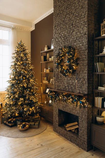 istock Stunning Christmas tree with blue and gold decorations, gifts beneath. Stone fireplace adorned with garland and wreath, perfect for a cozy and festive holiday setting 2168228157