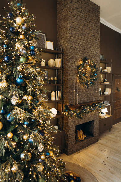 istock tylish holiday scene featuring a decorated Christmas tree with lights, a stone fireplace with festive garland and wreath. Shelves filled with decor enhance the cozy atmosphere 2168229170