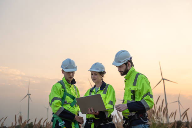istock Team of engineers working and using a computer laptop on site in wind turbine farm, Wind turbines generate clean energy source, Eco technology for electric 2168229394