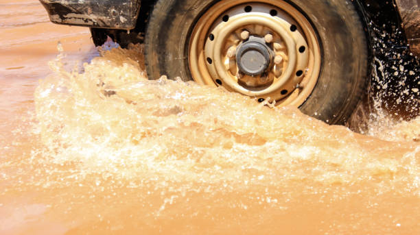 istock Floodwater splashing violently caused by a vehicle which is driven through. Vehicle Insurance concept 2168235230