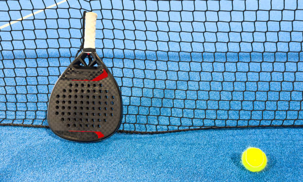 istock padel racket on a padel blue court with a ball 2168246044