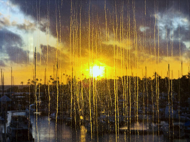 A beautiful sunset seen through raindrops and a window in Hawaii