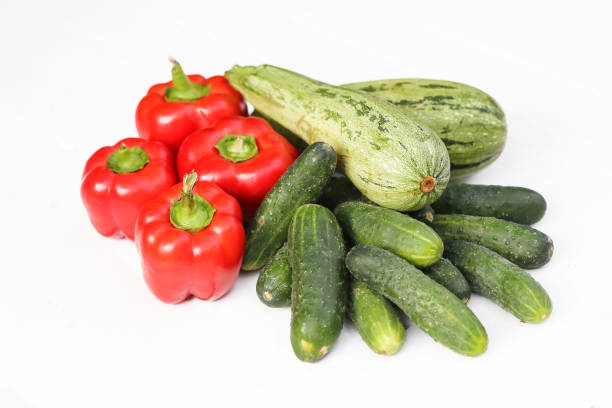 istock Fresh red bell peppers. Green cucumbers. Zucchini arranged on a white background. Vibrant vegetables. 2168257039