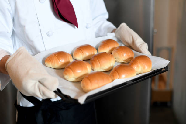 Baker's hands in chef coat making bread in the kitchen