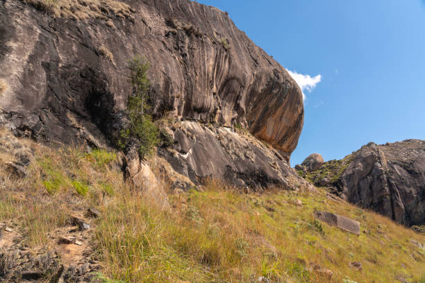 On person in distance hiking scenic mountain range, boulders, blue sky at the Anja Community Reserve Madagascar, where the most famous lemurs, live.
