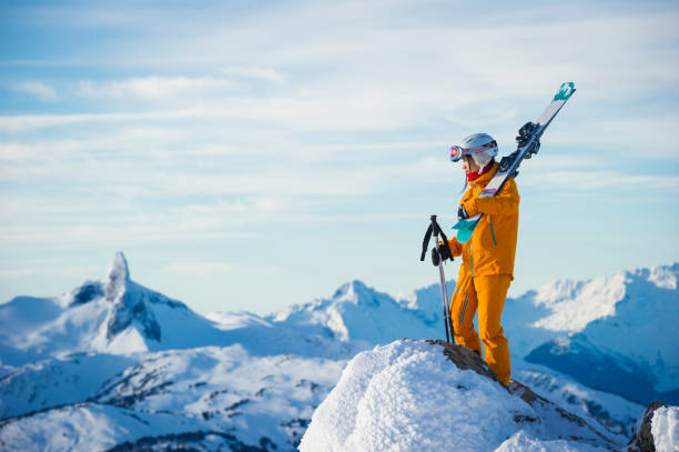 Portrait of young woman skier on mountain top Portrait of young woman skier on mountain top, Black Tusk spire in distance, Whistler, B.C. top of ski mountain stock pictures, royalty-free photos & images