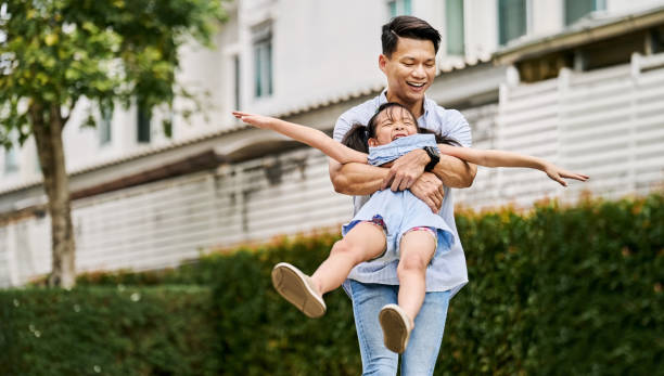 istock Dad holding and spinning daughter during playtime at park 2168270326