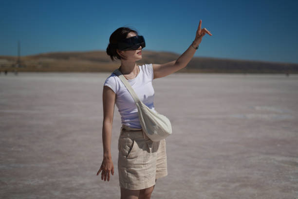 istock Beautiful young Asian female tourist using her virtual reality VR glasses, while exploring the Salt Lake in Konya Turkey, Turkiye. 2168273596