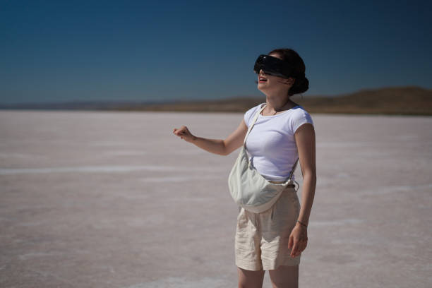 istock Beautiful young Asian female tourist using her virtual reality VR glasses, while exploring the Salt Lake in Konya Turkey, Turkiye. 2168274057