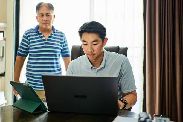 istock Man working from home with father standing in background 2168275332