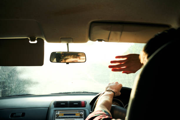 istock Young man driving his car outside on a sunny day 2168277494