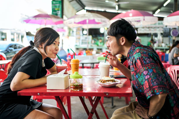 istock Young couple talking over a meal together in a sidewalk restaurant 2168277500