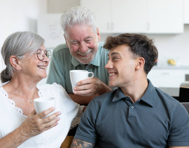 istock Happy multigenerational family sitting relaxing on sofa, grandparents drink a coffee cup while young grandson  uses laptop. Positive emotions 2168277689