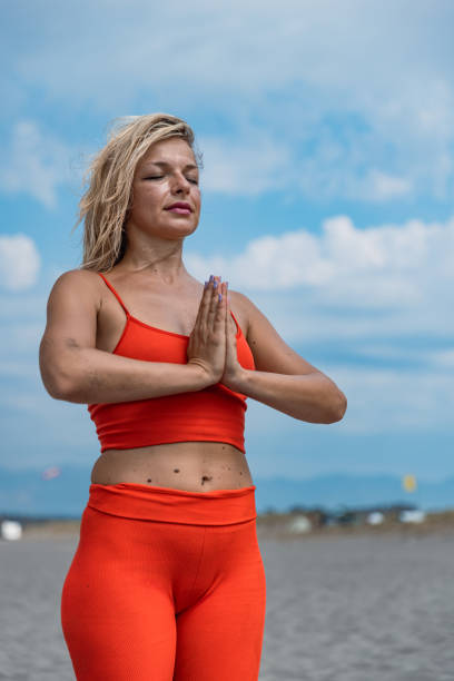 istock A Blonde woman practicing yoga on a beach 2168283407