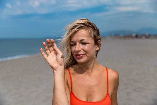 Happy Blonde Woman Smiling at a Bug on Her Hand - Stock Photo